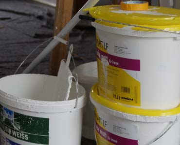 Kinyitott festékesvödrök és ecsetek