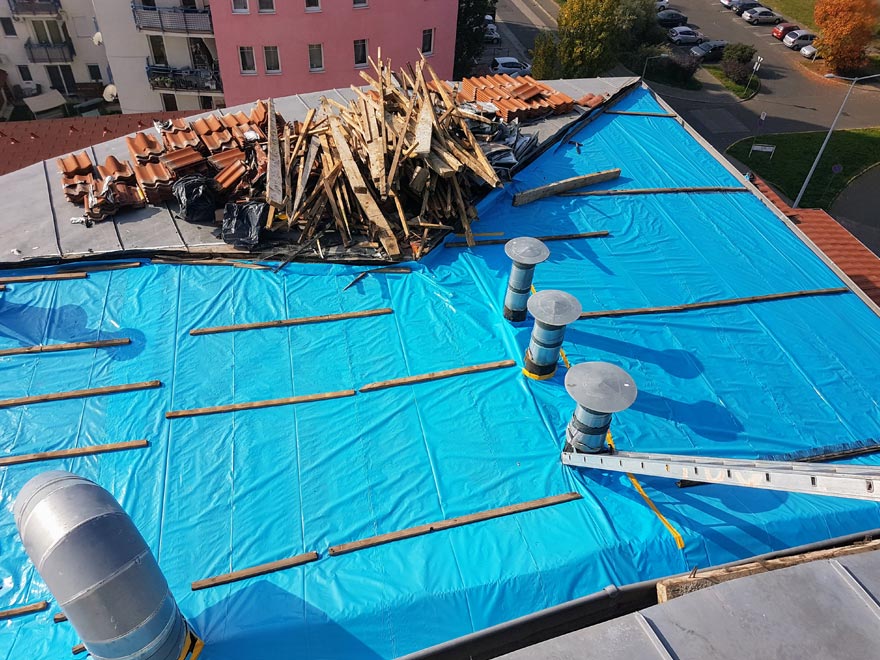 Lebontott tetőszerkezet és cserepek